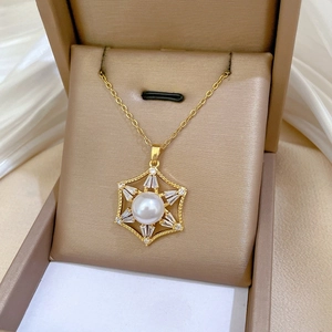 Detail of gold snowflake pendant necklace with hexagon zircons and center pearl