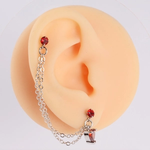Close-up of red heart zircon chain earrings on a model showing the double-hole drop design
