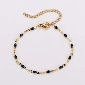 Detail of gold chain bracelet with black enamel oval links and lobster clasp closure