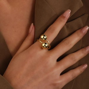 Close-up of 18k gold plated double-layer open ring featuring hollow ball design on finger
