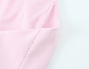 Detailed close-up of pink elastic fabric texture and fine stitching on the halter crop top
