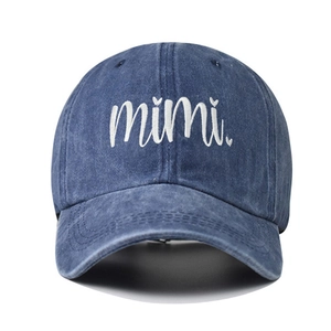 Close-up of white MIMI embroidery with heart on washed blue denim baseball cap detail