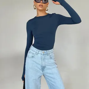 Detail view of a slim fit navy long sleeve top with thumb holes and light wash denim jeans