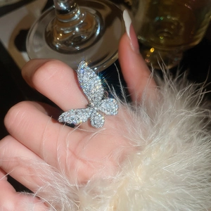 Detail of sparkling butterfly ring with zircons and polished silver finish on hand