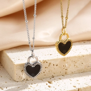 Minimalist heart lock necklace in silver and gold steel over elegant silk and stone background