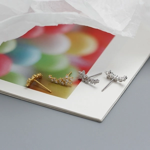 Detail shot of gold and silver flower stud earrings with sparkling pavé crystals