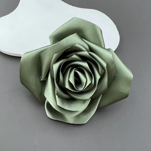 Detailed top view of a handmade olive green satin rose accessory with silk texture