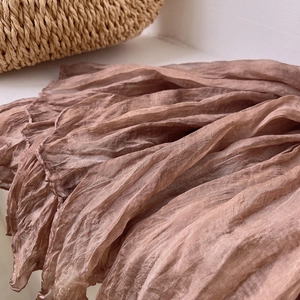 Macro detail of brown pleated vintage scarf fabric with retro tie-dye texture and soft light