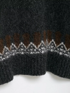 Detail of grey jacquard knit sweater featuring mohair texture and ribbed hem detail