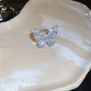 Dettaglio di un anello a farfalla scintillante con zirconi su vassoio a cuore