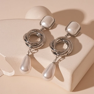 Dettaglio di orecchini a goccia d'argento con anelli geometrici e perle a goccia d'acqua