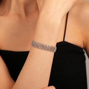 Detail of five-row cubic zirconia bracelet on wrist featuring silver plating and high shine