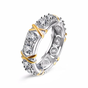 Close-up of twisted rope ring with gold X motifs and pavé-set heart-shaped zirconias