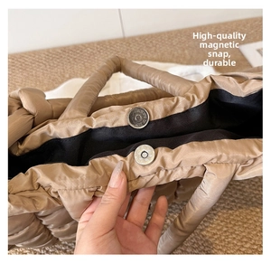 Close-up of a quilted tote bag featuring a durable magnetic snap button closure detail