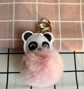 Detail of cute panda plush keychain with a soft pink faux fur pompom and golden metal clasp