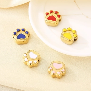 Detail of colorful enamel cat paw beads in gold finish for jewelry DIY crafting
