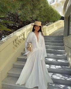 Detail view of white maxi dress featuring elegant ruffle V-neck and flowing wide sleeves