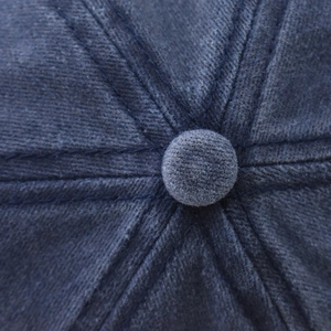Vue macro du haut de la casquette en coton avec coutures et bouton de fermeture