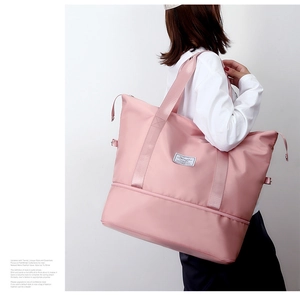 Pink waterproof travel bag detail showing wide straps and separate shoe compartment