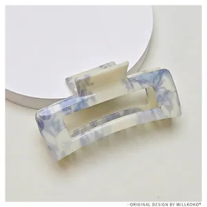 Detail of a rectangle floral claw clip with blue flowers on a cream white background
