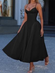 Elegant black spaghetti strap maxi dress with a full skirt in a European porch setting