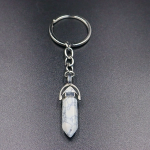 Detail of a white turquoise hexagonal prism crystal pendant on a silver keychain