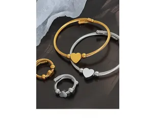 Detail of twisted cable jewelry set with gold and silver heart charms on dark texture