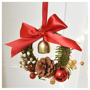 Close-up of Christmas wreath with red bow, gold bells, and natural pine cones decoration