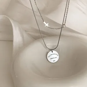 Double-layered stainless steel necklace featuring a cross pendant and engraved coin disc