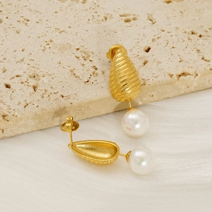 Boucles d'oreilles goutte en or 18K texturé avec perles blanches sur fond de soie