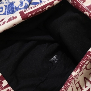 Macro shot of black knit lining and fabric wash care label on red and blue patterned beanie