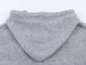 Detailed close-up of dark grey hooded knit cardigan with stars and soft wool texture