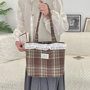 Close-up of vintage brown plaid tote bag with double-layer white lace trim and Happy patch