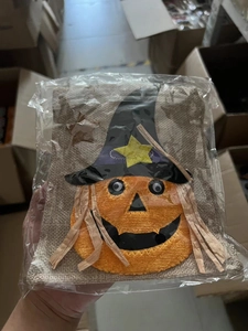 Detail showing a Halloween drawstring gift bag featuring a pumpkin and wizard hat design