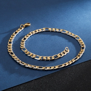 Detail of two-tone gold and silver Figaro chain necklace with a polished metallic finish