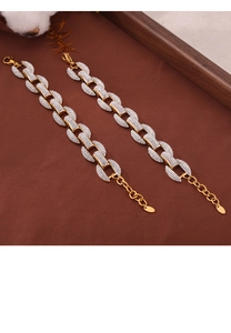 Detail of two-tone gold and silver rhinestone intertwined bracelets on fabric