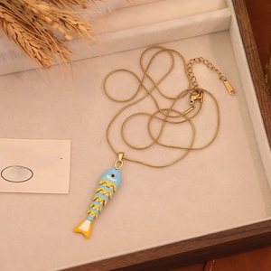 Macro detail of a colorful enamel koi fish pendant on a gold stainless steel chain