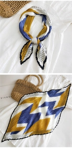 Dettaglio di un foulard in seta plissettata con motivi geometrici e colori vivaci