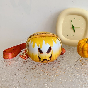 Detail of yellow pumpkin crossbody bag with whimsical face and wide orange strap