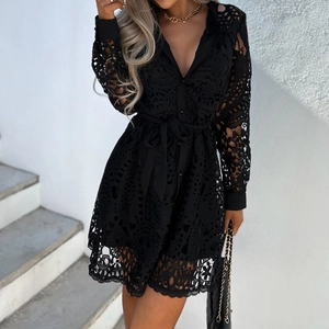 Détail du tissu en dentelle noire ajourée et manches longues boutonnées sur robe