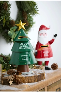 Detail of Christmas tree shaped metal mailbox with festive gold star and holiday lettering