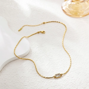 Detail of 18k gold plated flat weave chain and rectangular clear zircon pendant