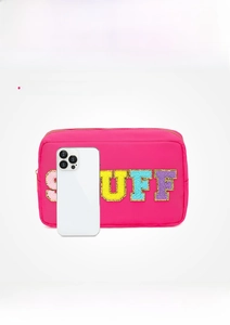 Trousse à maquillage rose avec broderie STUFF à côté d'un téléphone pour la taille