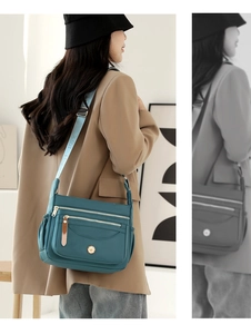 Detail view of water-resistant nylon crossbody bag with multi-pocket design in peacock blue