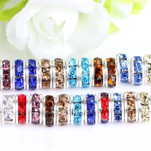 Macro view of colorful rhinestone spacer beads for DIY jewelry making on white background