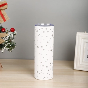 Detail of a 20oz white stainless steel tumbler with silver stars in a holiday setting