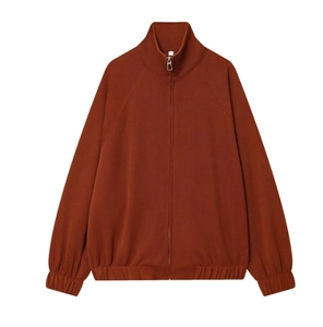Detail of caramel brown zip-up hoodie featuring ribbed cuffs and cotton knit texture