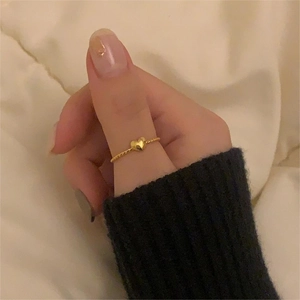 Close-up of a minimalist S925 sterling silver heart ring worn on a model hand