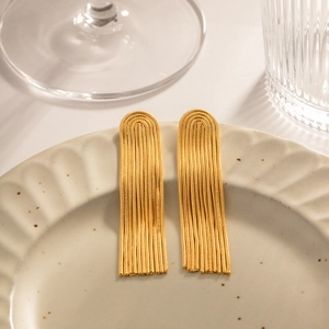 Elegant gold U-shaped long tassel earrings made of stainless steel on ceramic tray