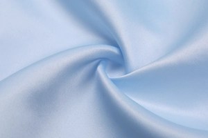 Close-up of premium light blue satin fabric showing smooth texture and elegant drapes